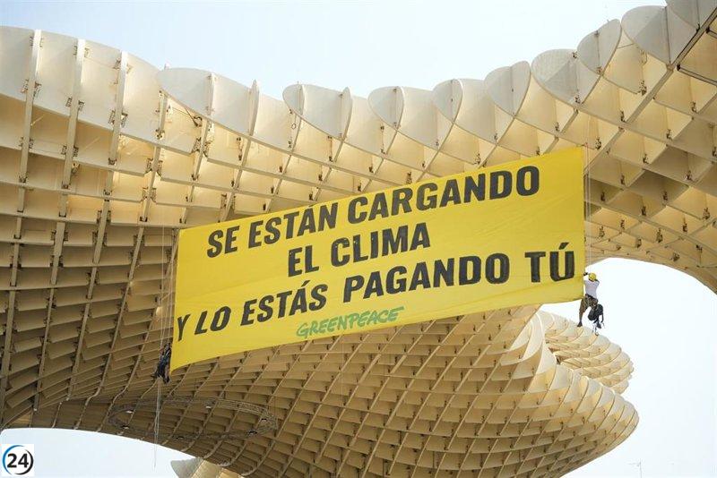 Gran pancarta en Las Setas de Sevilla exige regulaciones fiscales para la industria de los combustibles fósiles.